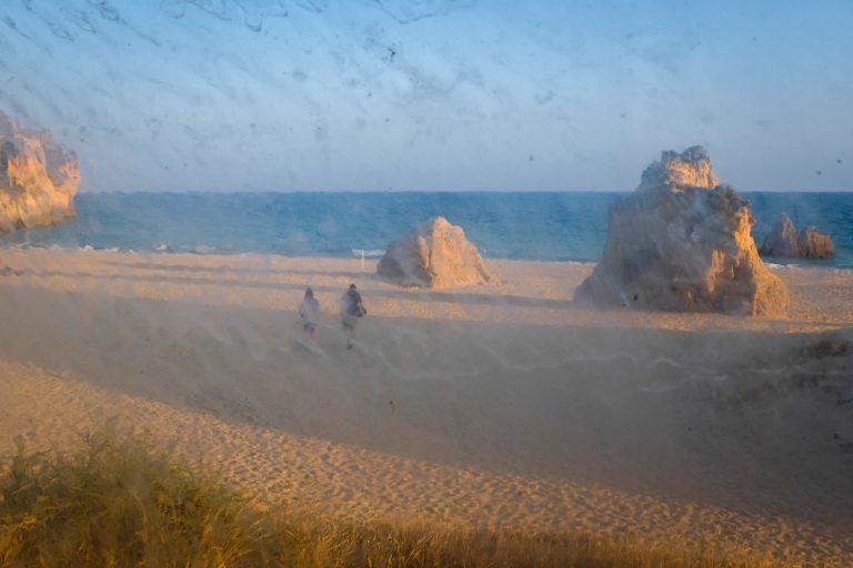 Street photo in Praia dos Tres Irmaos, Portugal by David Rathbone