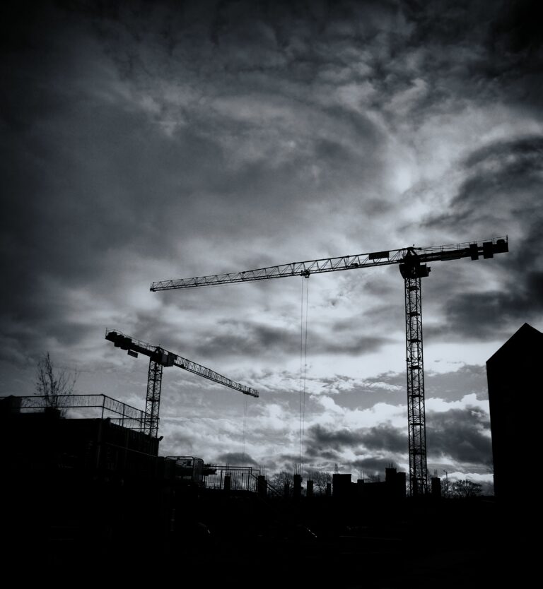 Dramatic skyline with construction cranes in silhouette